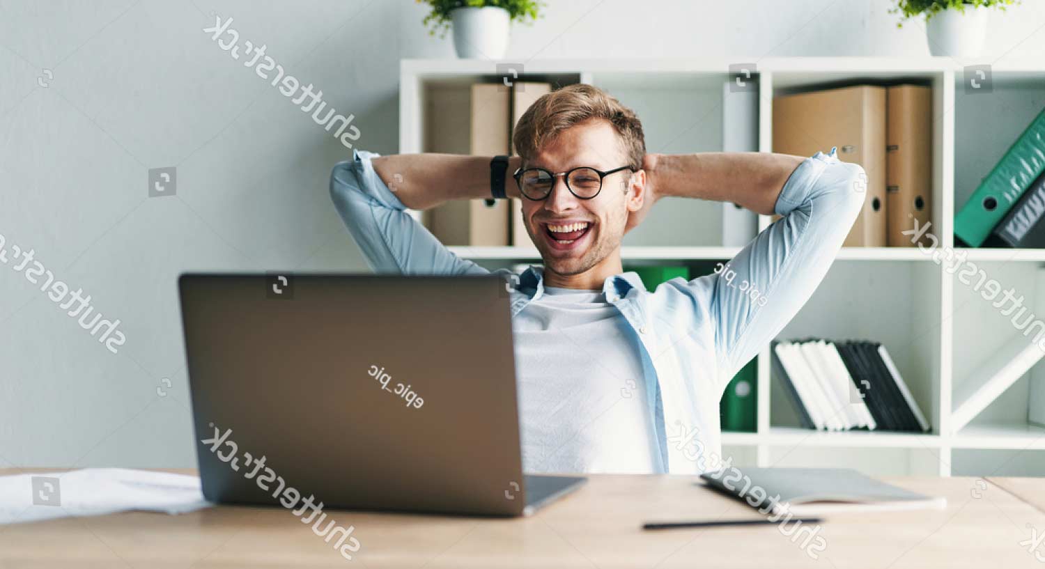 stock-photo-young-man-smiling-as-he-reads-the-screen-of-a-laptop-computer-while-relaxing-working-on-a-1676569027_flipped
